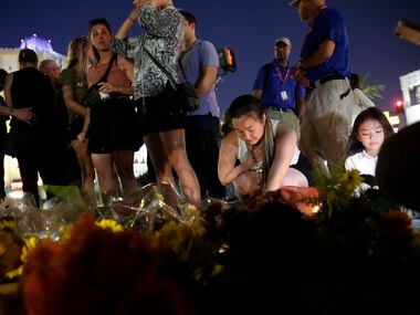 People pause at a memorial set up for victims of a mass shooting in Las Vegas, on Tuesday,...
