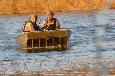 Texas National Guard soldiers ride a boat on the Rio Grande at the Shelby Park area,...