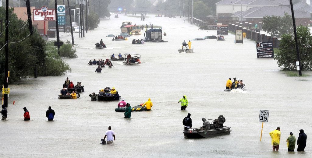 In this Aug. 28 photo, rescue boats fill a flooded street as flood victims are evacuated as...