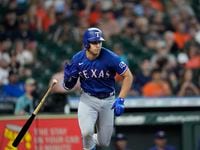 Texas Rangers' Nathaniel Lowe drops his bat after hitting a RBI single against the Houston...