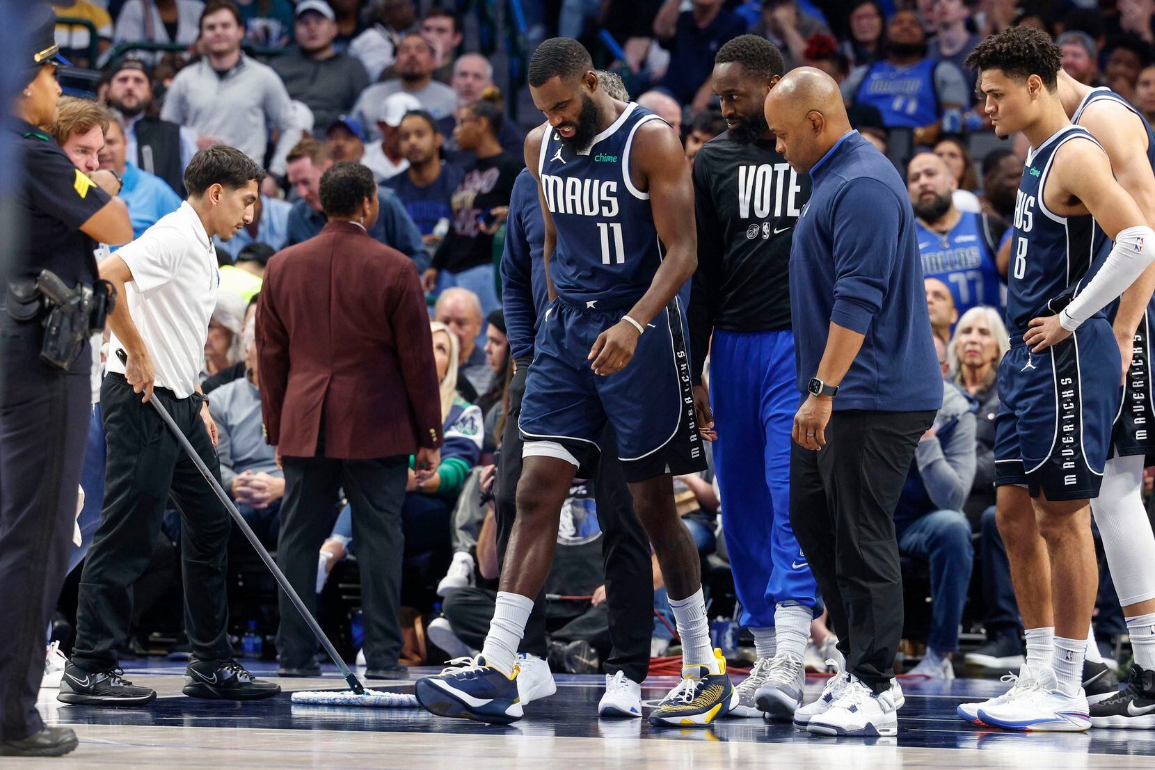 Dallas Mavericks forward Tim Hardaway Jr. (11) limps off the court after slipping on the...