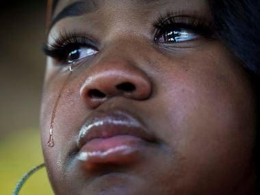 A tear runs down the cheek of MacKenzie Mitchell, one of the protest organizers, during a...