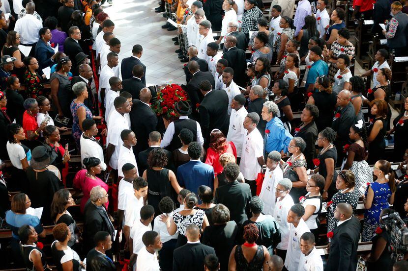 Botham Shem Jean is carried by pallbearers and followed by family at the start of the...