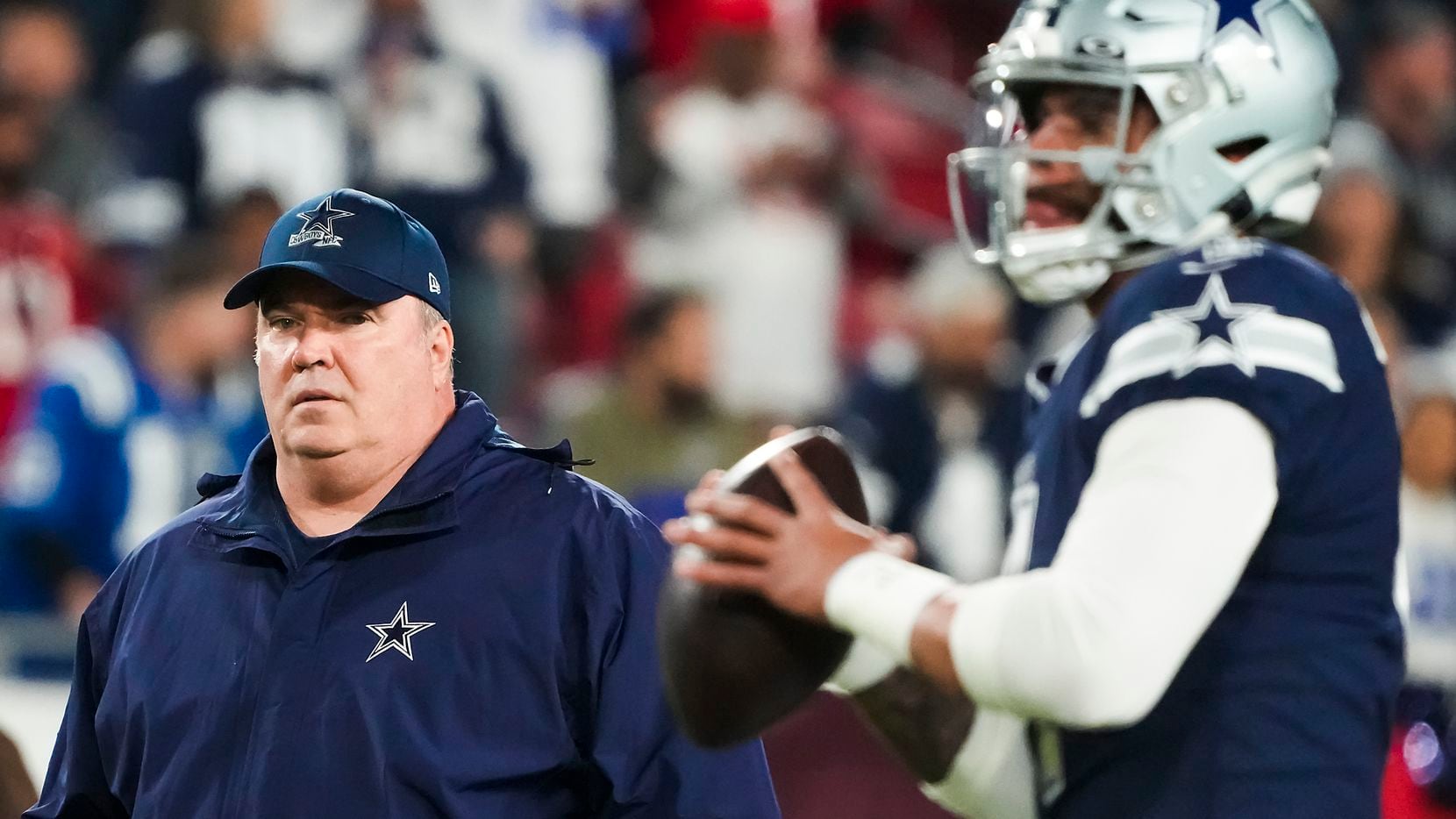 Dallas Cowboys head coach Mike McCarthy watches quarterback Dak Prescott warm up before an...