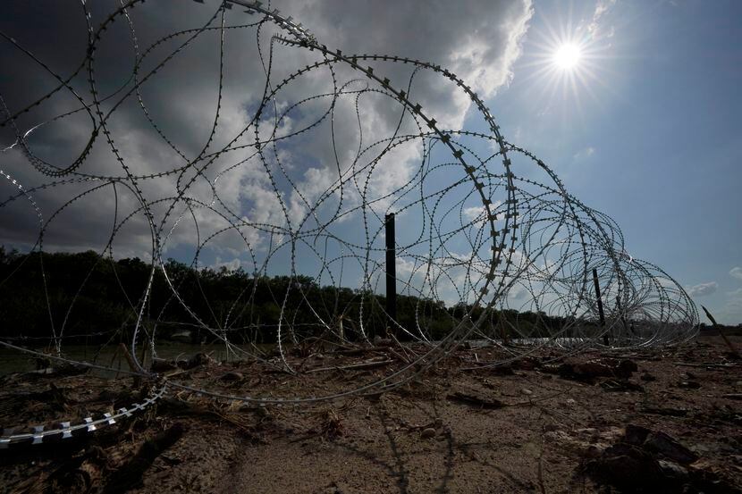FILE - Concertina wire lines the banks of the Rio Grande on the Pecan farm of Hugo and...