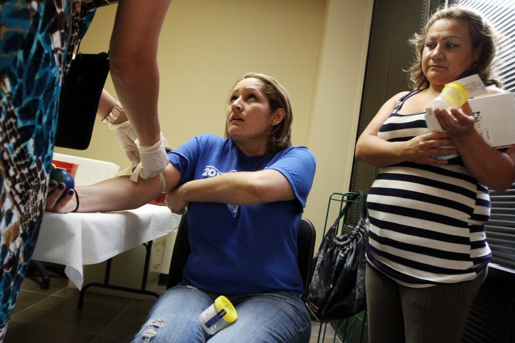 A woman is tested for HIV by a Dallas County Health Department worker at the Mexican Consulate.