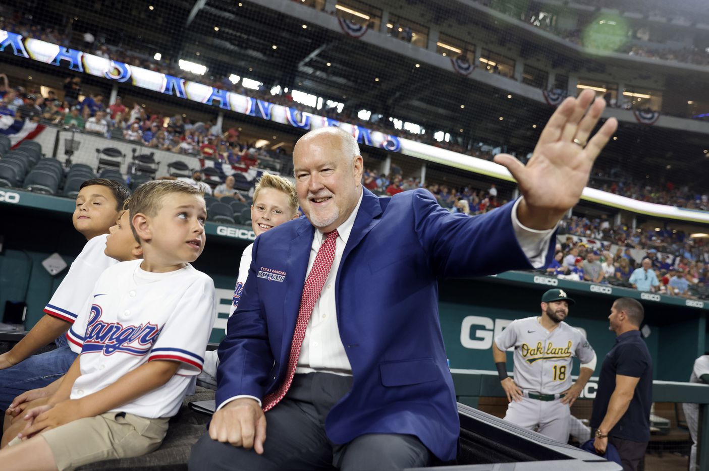 Texas Rangers executive vice president and public address announcer Chuck Morgan waves to ball players following his induction into the Texas Rangers Baseball Hall of Fame at Globe Life Field in Arlington, Saturday, August 14, 2021.(Tom Fox/The Dallas Morning News)