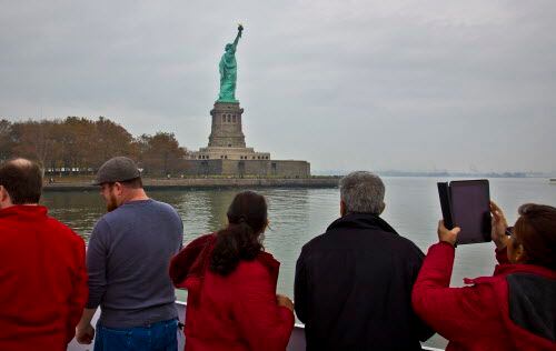 Unos visitantes observan la Estatua de la Libertad. Foto AP
