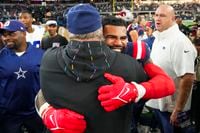 New England Patriots running back Ezekiel Elliott hugs Dallas Cowboys head coach Mike...