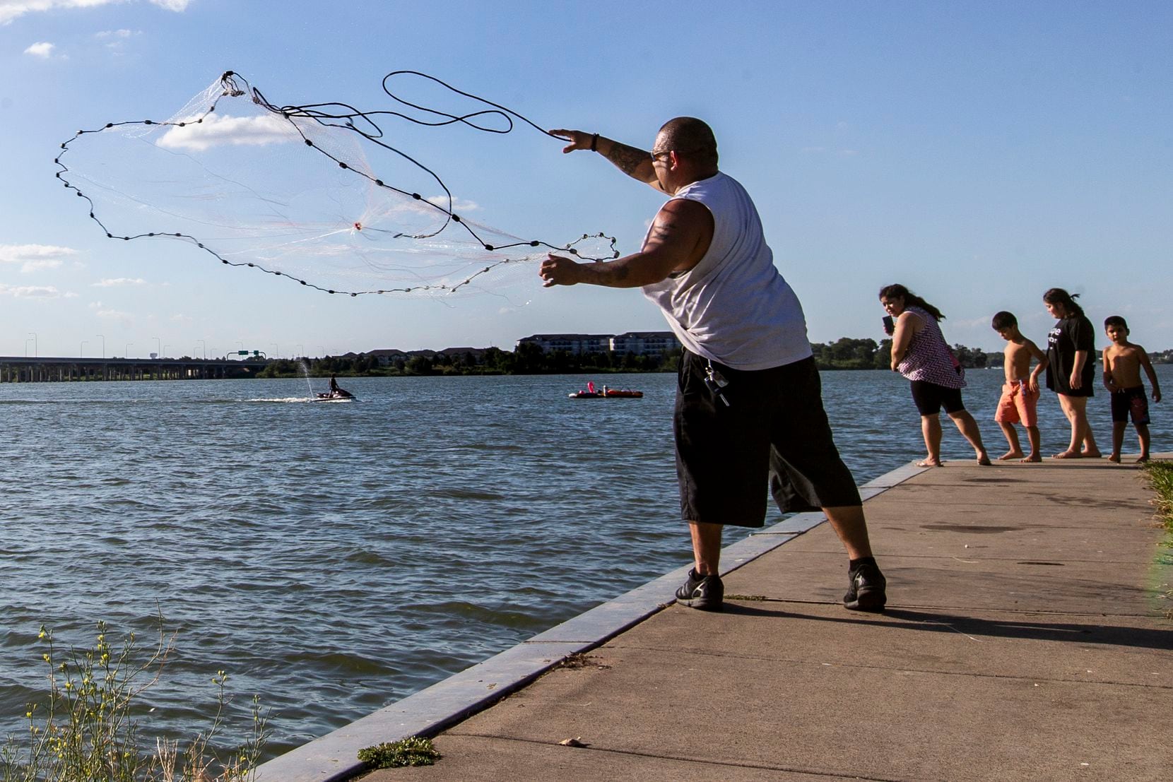 A fisherman, who wished to remain unidentified, casts a net at the John Paul Jones Park along Lake Ray Hubbard in Garland, Texas, on Saturday, July 18, 2020.