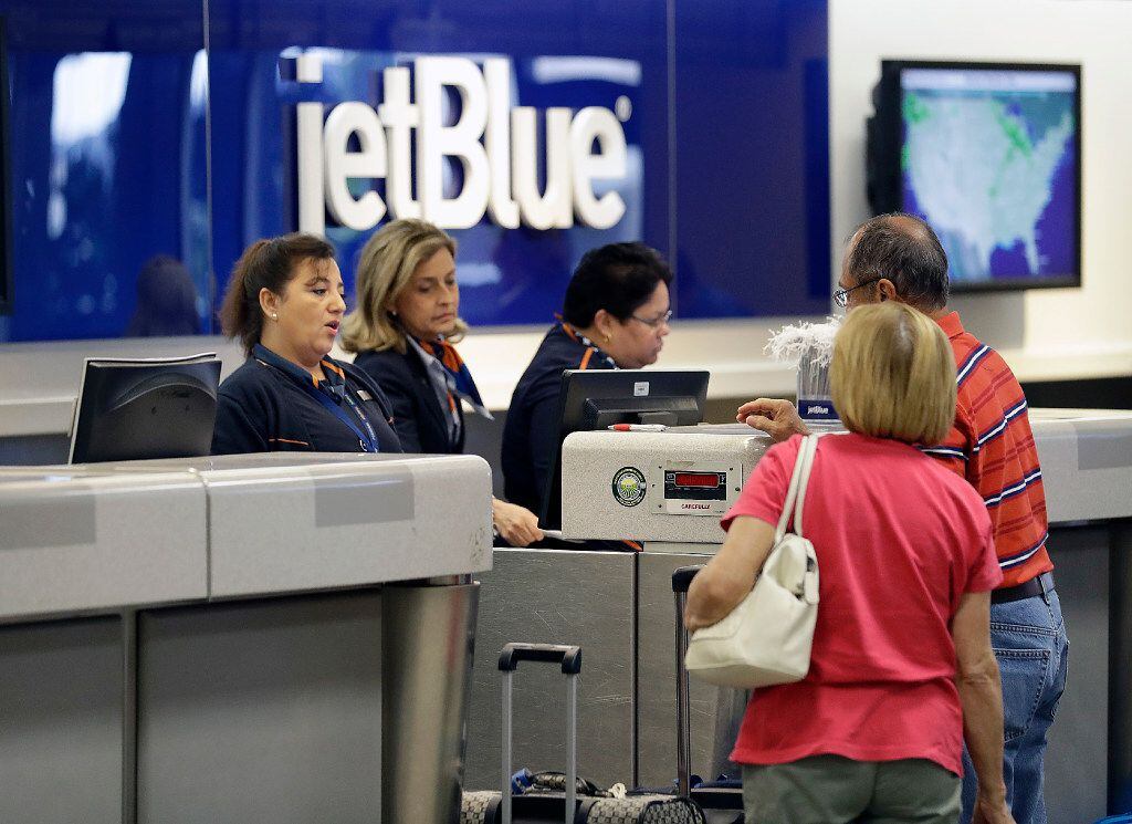 In this Wednesday, Oct. 26, 2016, photo, JetBlue Airways ticket agents assist passengers at...