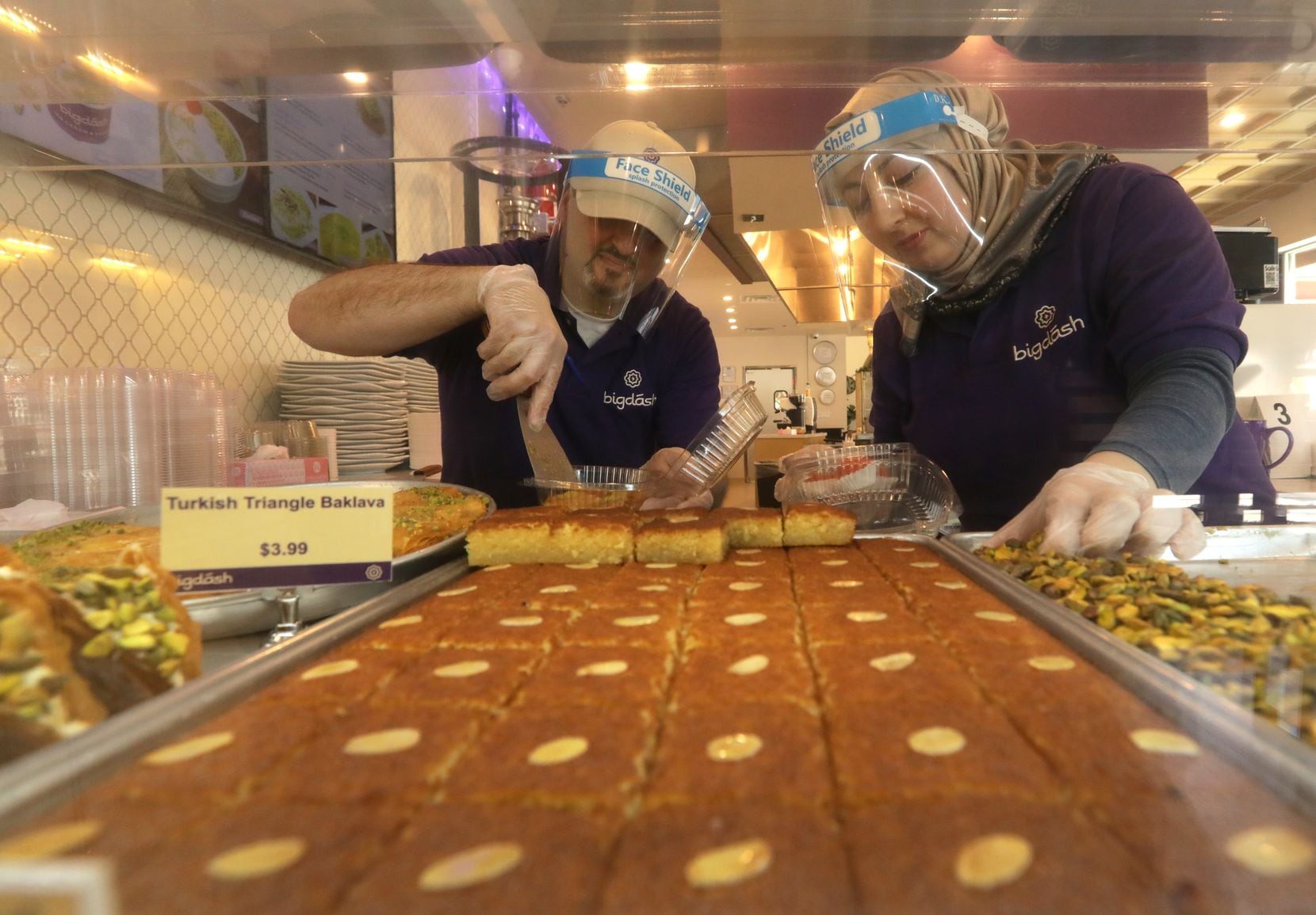 Kareem Alrefaai, left, and Asmaa Khattab prepare a plate of desserts at Big Dash in Frisco, TX, on Apr. 16, 2020. (Jason Janik/Special Contributor)