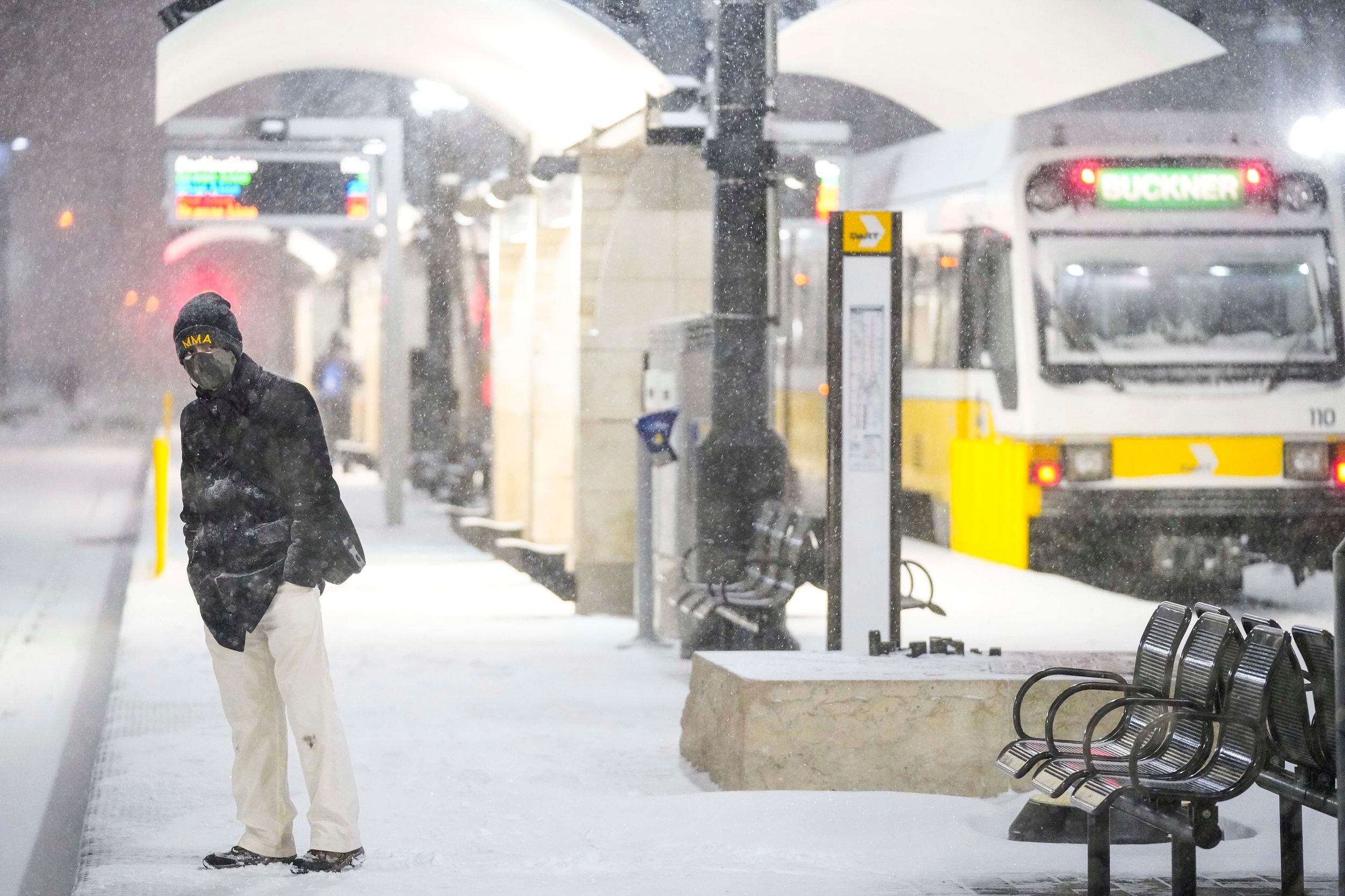 Victor Escamilla looks down the tracks as people wait in driving snow at the Pearl/Arts...