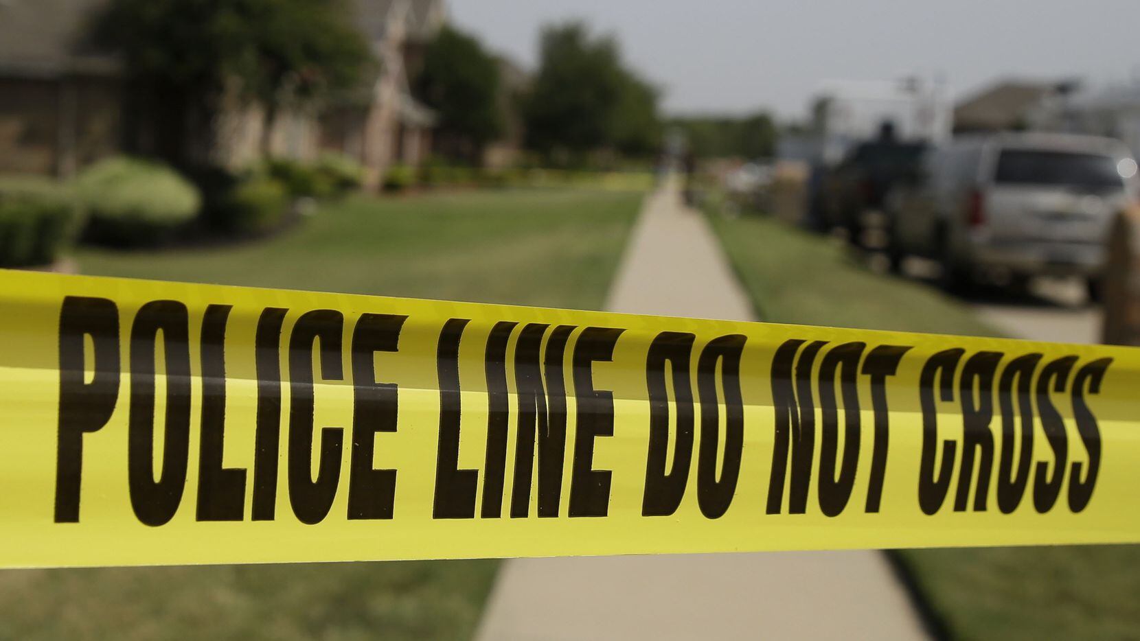 Crime scene tape marks off the area law enforcement investigators are working outside the...
