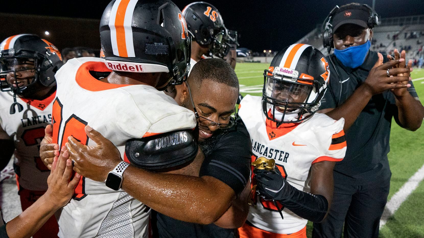 Lancaster head coach Leon Paul is congratulated by running back Isaiah Broadway (20) and...