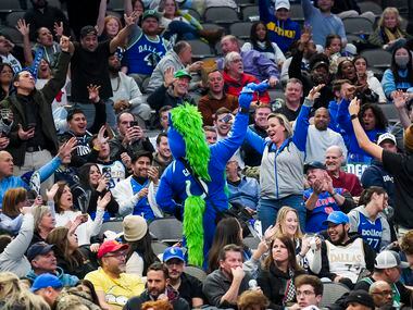 Dallas Mavericks fans cheer mascot Champ during the second half of an NBA basketball game...