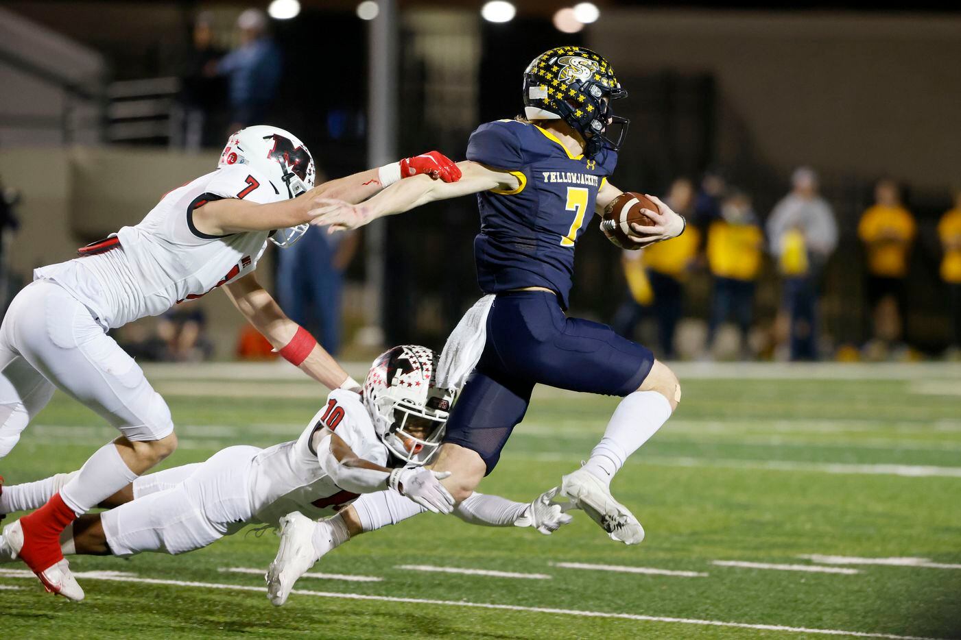 Melissa’s Gunnar Wilson (7) and Parrish Adger (10) tackle Stephenville quarterback Ryder Lambert (7) during the first half of a Class 4A Division I Region II final high school football game in Bedford, Texas on Friday, Dec. 3, 2021. (Michael Ainsworth/Special Contributor)
