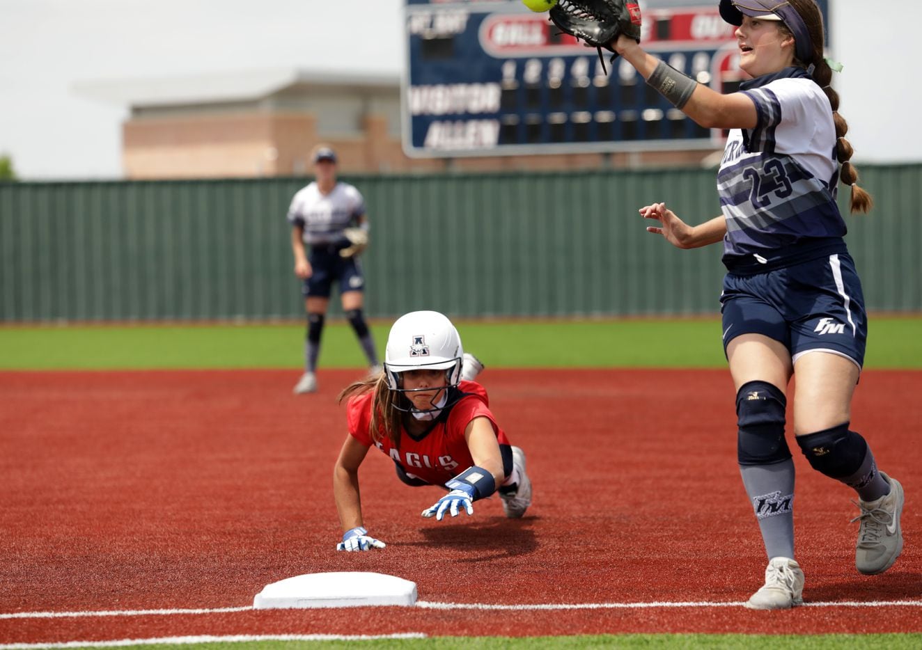 Allen High School player #17, Chloe Schimmel, slides back into first base during a softball...