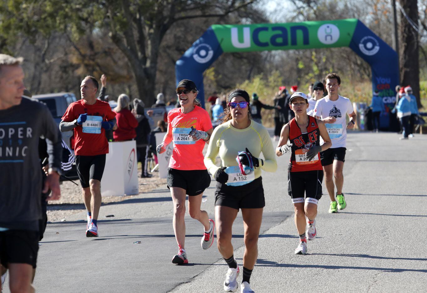 Runners pass a water station during the BMW Dallas Marathon at White Rock Lake in Dallas,...