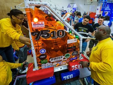Don Prier (right) works with his Spring Woods High School robotics team in the pits during...