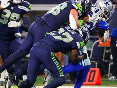 Dallas Cowboys running back Malik Davis (34) is pulled down by Seattle Seahawks safety...
