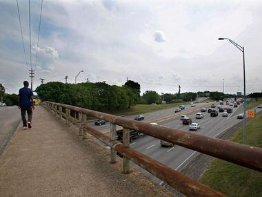 A pedestrian crosses the Ewing Street overpass over I-35E near the Dallas Zoo in Dallas...