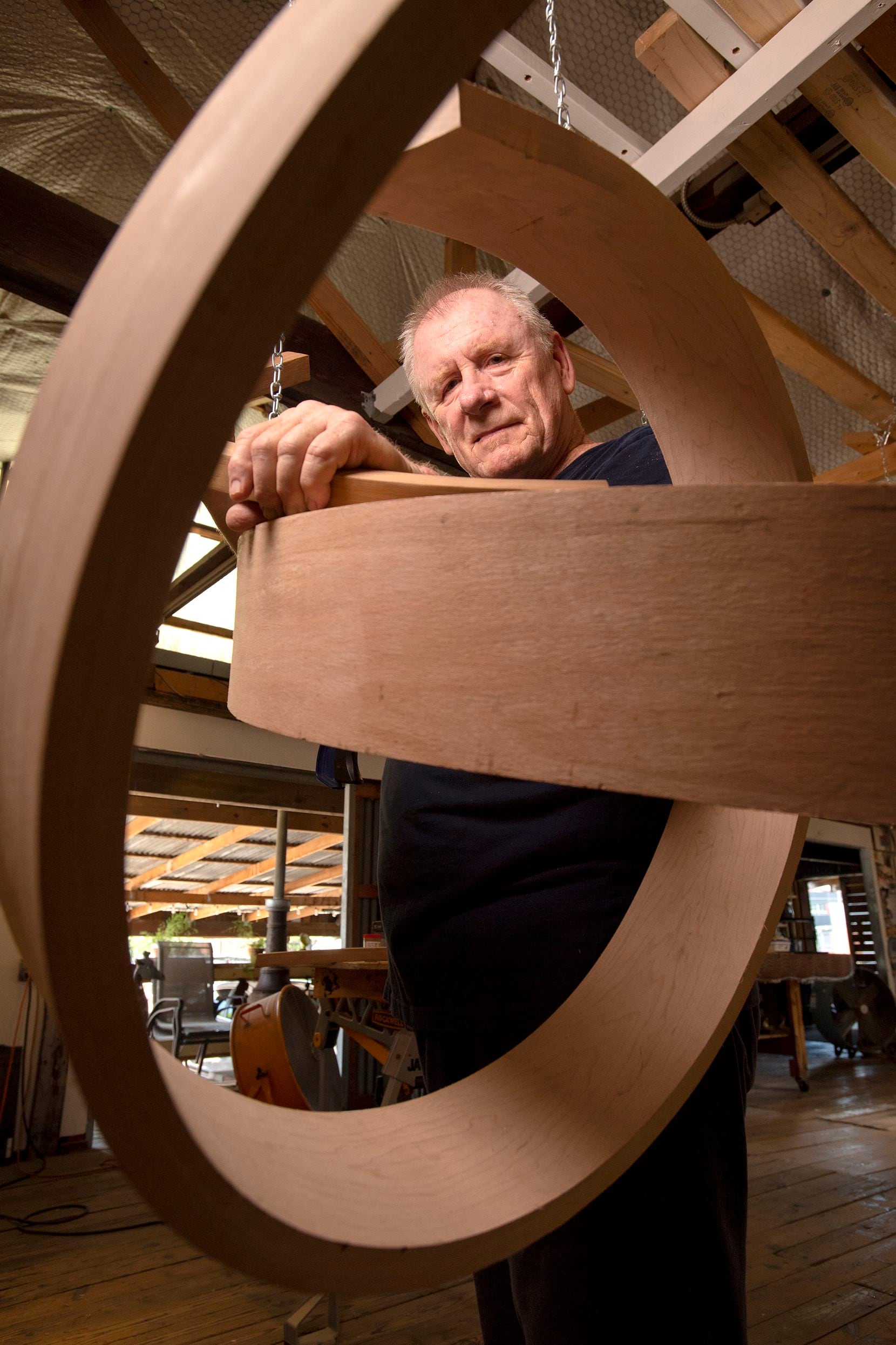 Wood sculptor Rick Maxwell poses with an unfinished sculpture. 