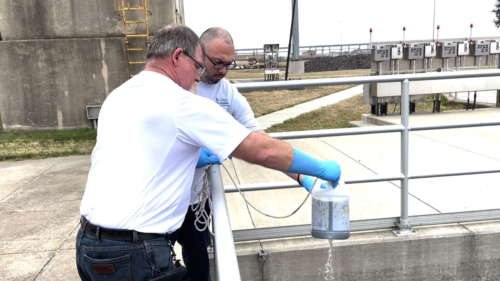 Larry Middleton, front, operations supervisor of Central Wastewater Treatment Plant, pours...