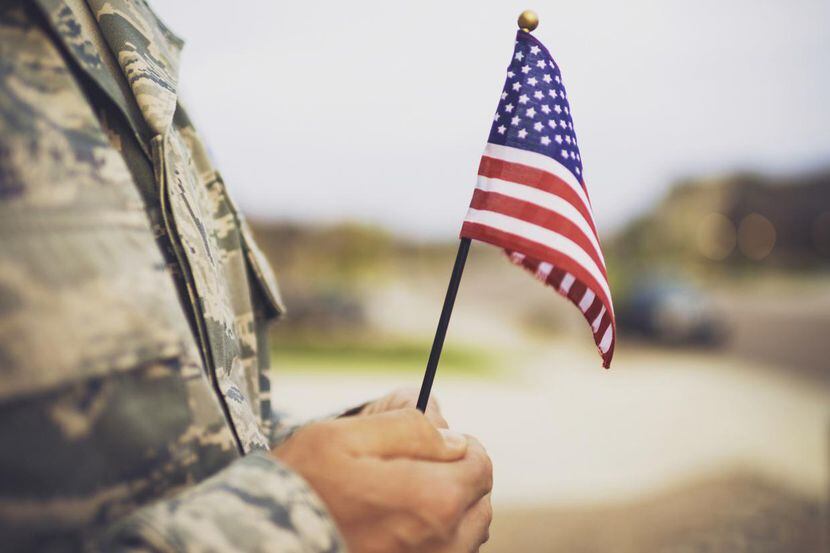 Un soldado de las fuerzas armadas con una bandera estadounidense en sus manos.(GETTY IMAGES)
