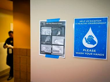Signs advocate hand washing and CDC guidelines for stopping the spread of the new...