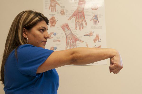 Brenda Alvarez demonstrates Step 8 of an arm exercise to alleviate hand pain.