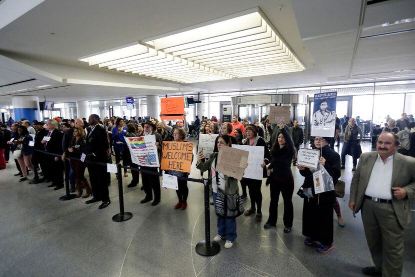 Protesters hold signs at San Francisco International Airport to denounce President Donald...