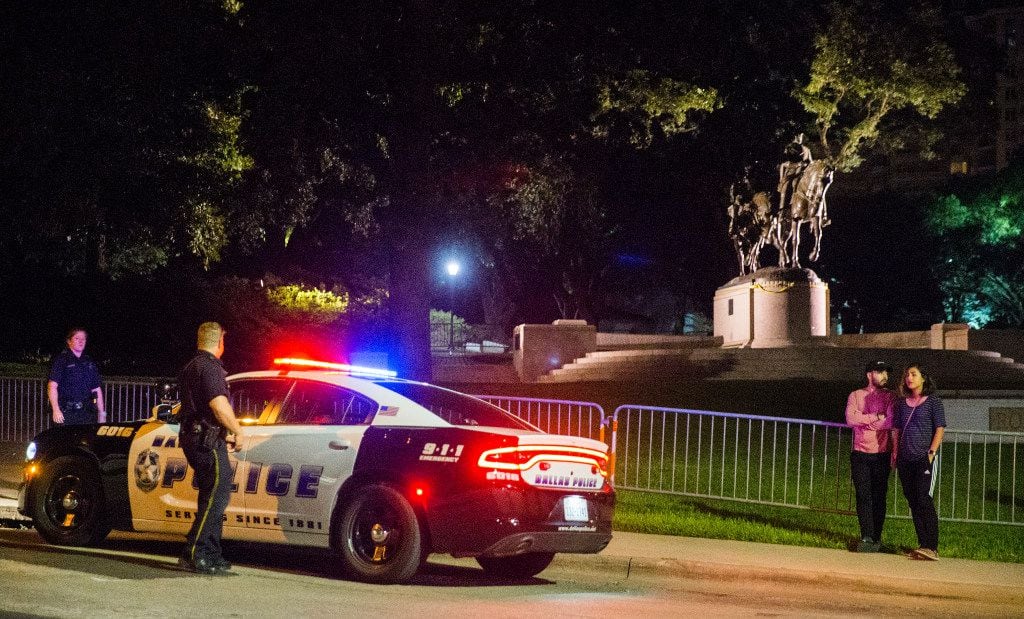 Police officers patrol the area around a statue of Robert E. Lee around 10:30 p.m. on...