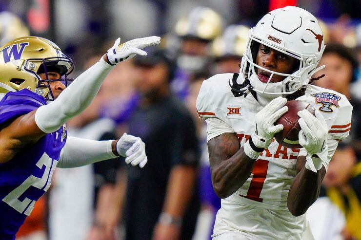 Texas wide receiver Xavier Worthy (1) makes a catch while covered by Washington cornerback...