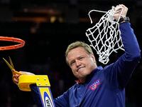 Kansas head coach Bill Self cuts the net after their win against North Carolina in a college...