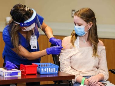 Madeleine Jenkins, 15, Judge Clay Jenkins' daughter, receives a COVID-19 vaccine as the first minor under 16 years old to get vaccinated in Dallas County at WISH Clinic Building at Parkland Memorial Hospital in Dallas on Thursday, May 13, 2021. (Lola Gomez/The Dallas Morning News)