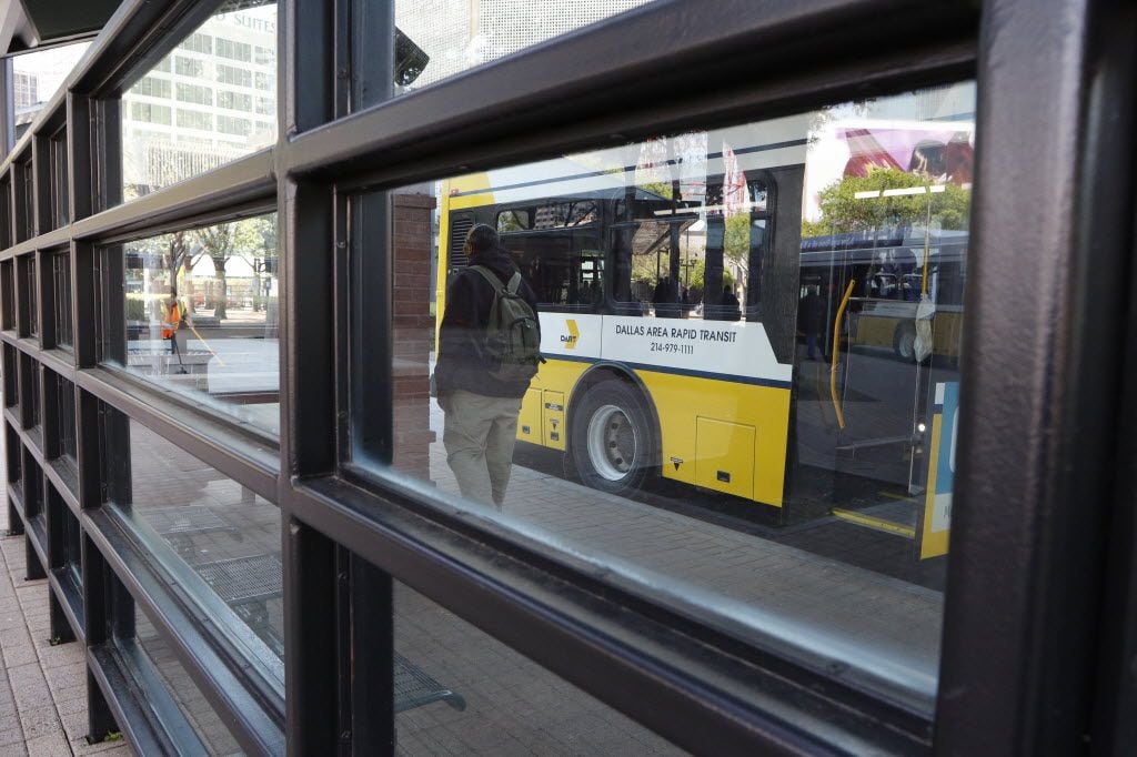 People wait at the DART West Transfer Center for DART buses in downtown Dallas on Friday,...