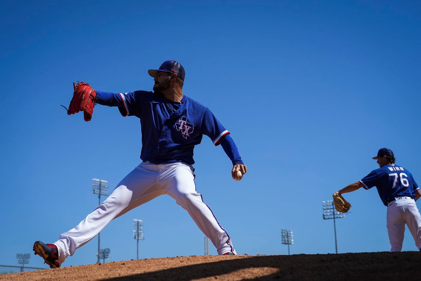 Texas Rangers pitcher Marin Perez throws in the bullpen with Cole Winn during a spring...