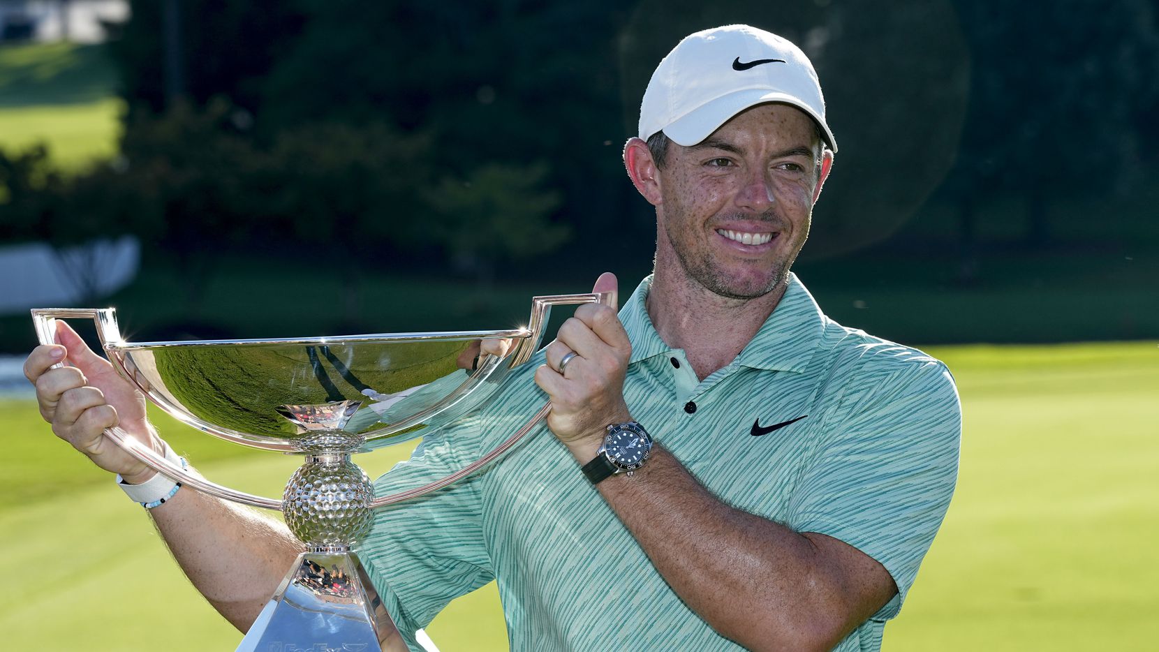 Rory McIlroy, of Northern Ireland, holds the championchip trophy after winn...