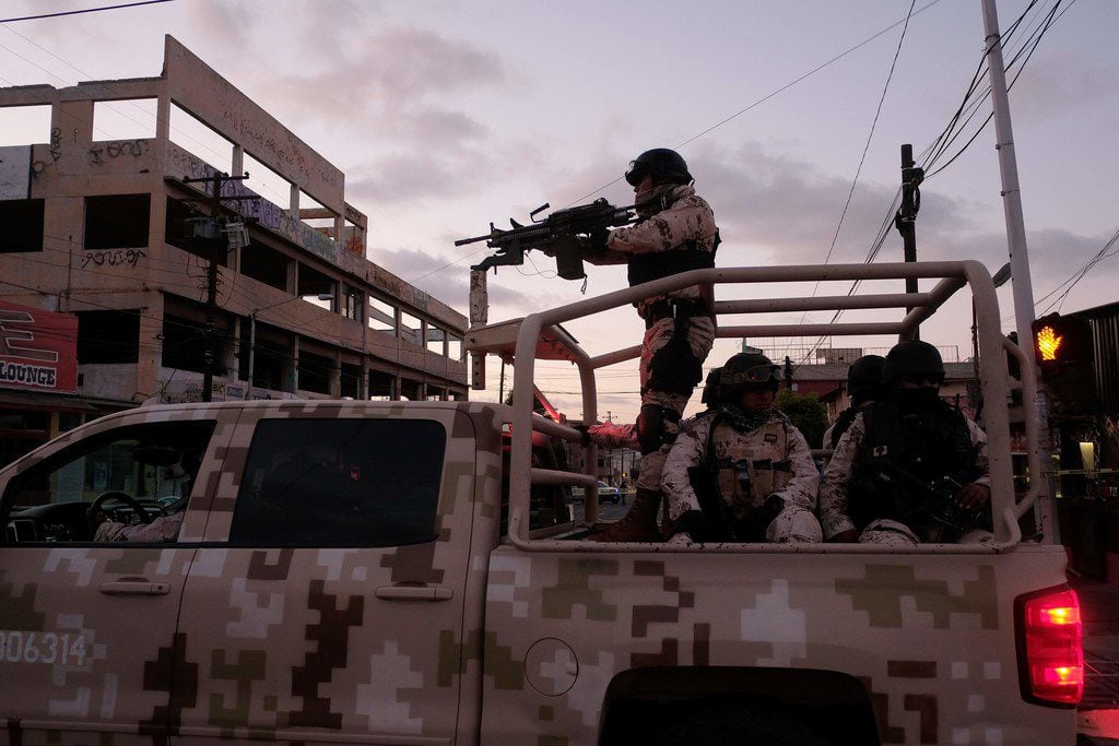 Mexican soldiers leave the scene of a crime where a man was killed by gun fire in downtown...