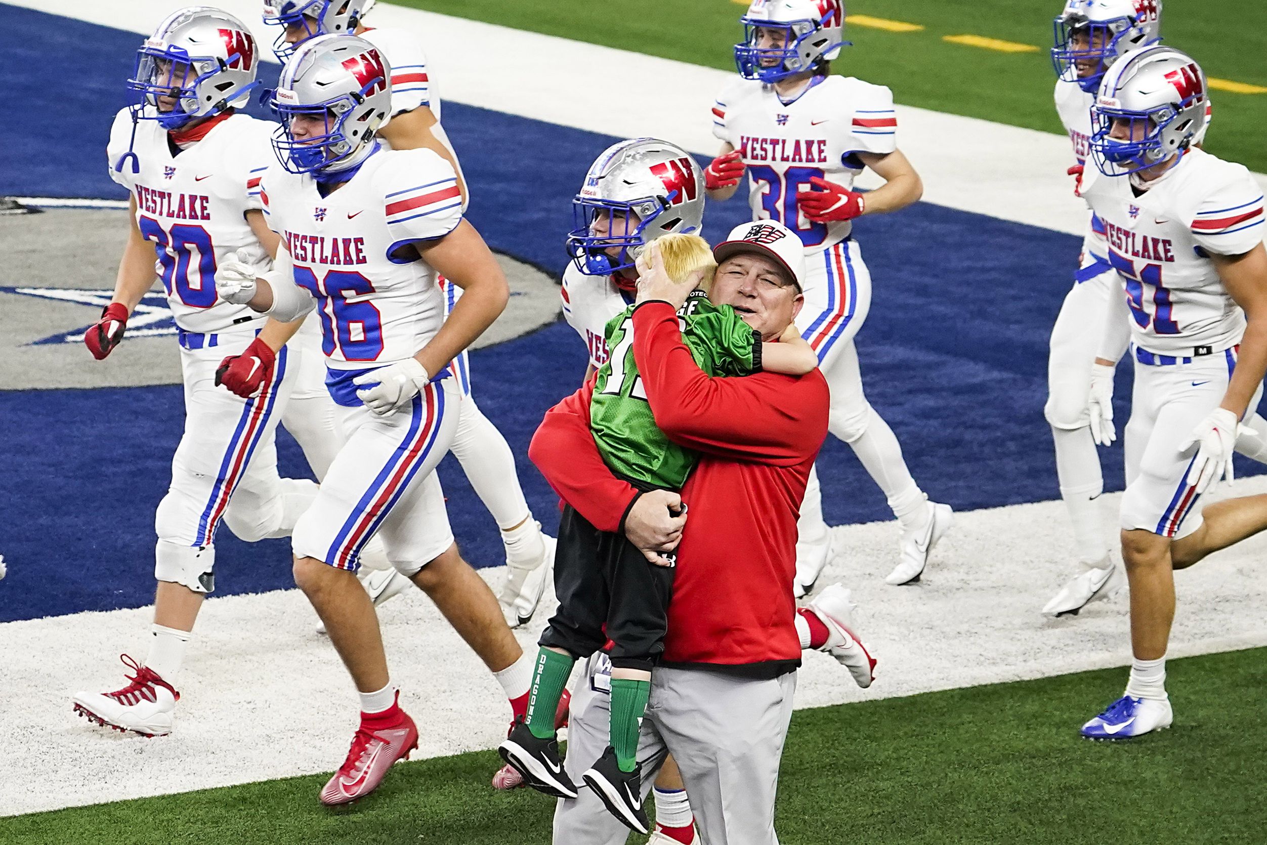 Austin Westlake head coach Todd Dodge hugs his grandson Tate, 5, as his team takes the field...