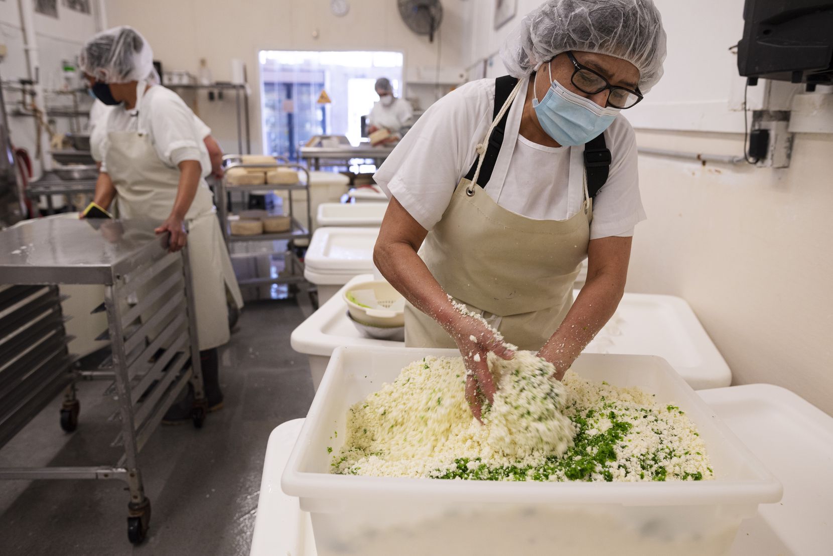 Carmen Lopez mixes jalapeño and epazote herb into queso blanco as she prepares a variety of...