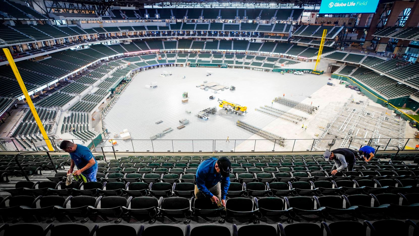 Crews clean seats on the upper concourse at the Texas Rangers' new Globe Life Field as...