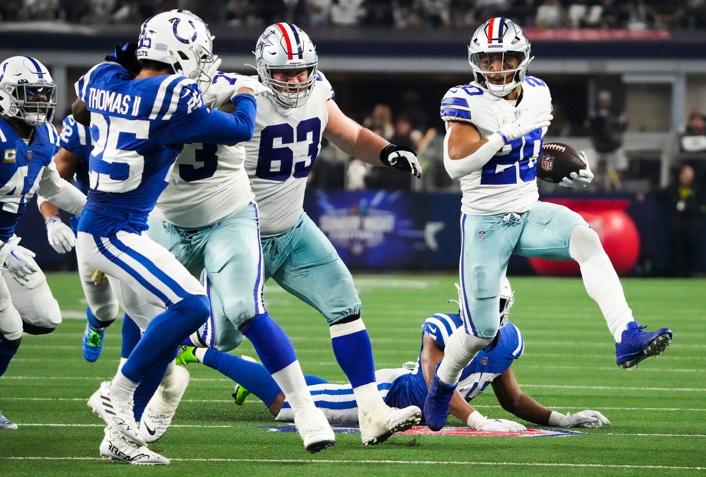 Dallas Cowboys running back Tony Pollard (20) breaks through the Indianapolis Colts defense...