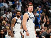 Dallas Mavericks guard Luka Doncic (77) and guard Kyrie Irving (2) wait for play to begin...