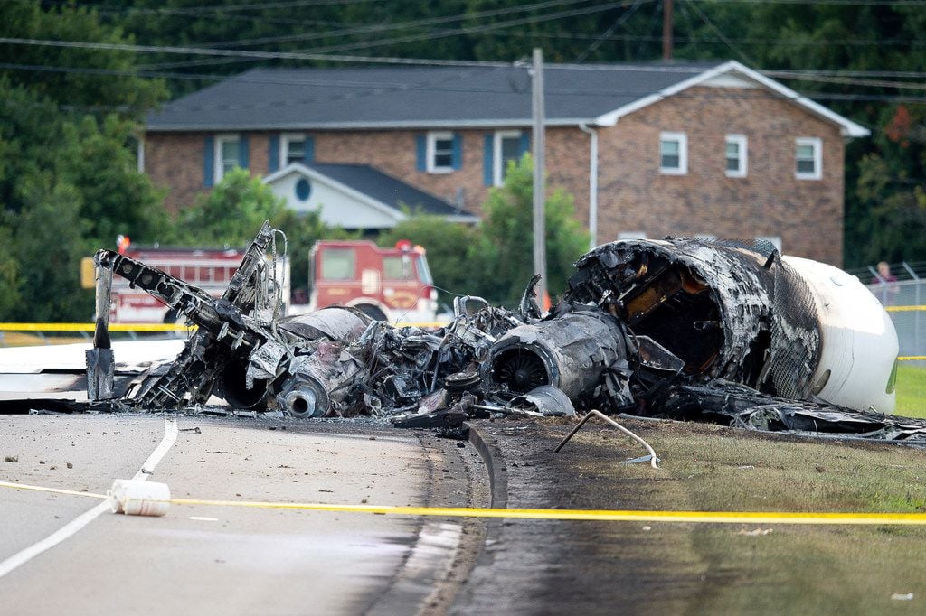 The charred remains of a plane lie along Highway 91 near Elizabethton Municipal Airport in Elizabethton, Tenn., after a crash landing Thursday, Aug. 15, 2019. Dale Earnhardt Jr., his wife and daughter were on board the plane. everyone on board survived. (Calvin Mattheis/Knoxville News Sentinel via AP)
