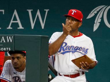 Texas Rangers interim manager Tony Beasley (27) flashes a sign during the first inning of a...