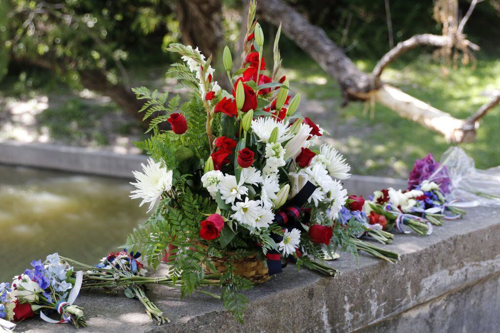Flowers and candles were placed on a bridge at Stonebridge Drive on Turtle Creek as a...