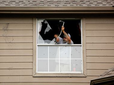Dan Creel of Armstrong's Glass and Mirror removes a broken window from the home of Randy...