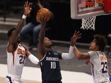 Dallas Mavericks forward Dorian Finney-Smith (10) attempts a shot in between Phoenix Suns...